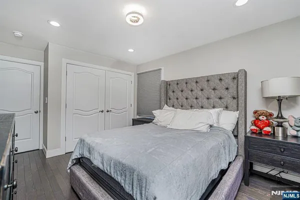 a bedroom with a bed and a lamp on dresser