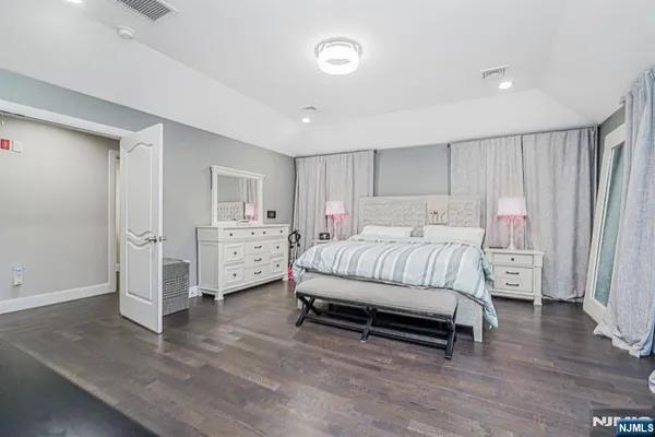 a spacious bedroom with a bed and a view of kitchen