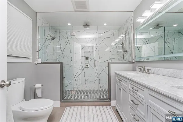 a bathroom with a sink a toilet and shower