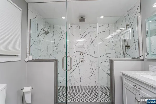 a bathroom with a sink a toilet and shower