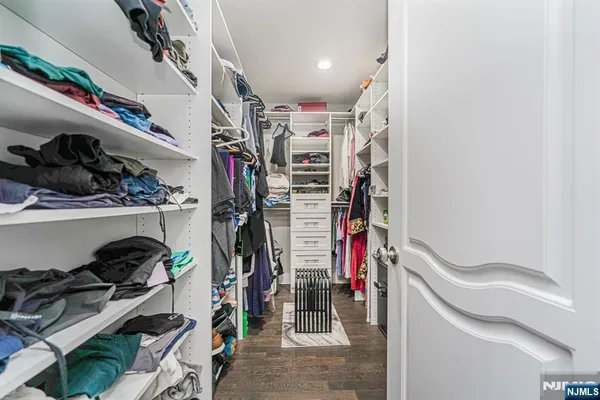 a view of walk in closet with clothes and shoes