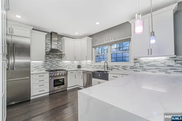 a kitchen with stainless steel appliances granite countertop a sink stove and refrigerator