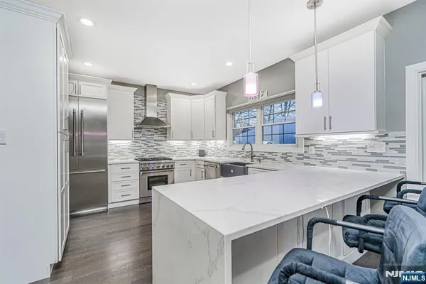 a kitchen with a refrigerator a sink and wooden floor