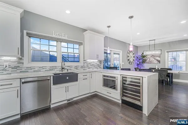 a kitchen with stainless steel appliances granite countertop hardwood floor sink stove dining table and chairs