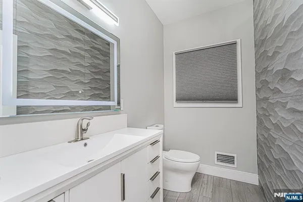 a bathroom with a toilet a sink and mirror