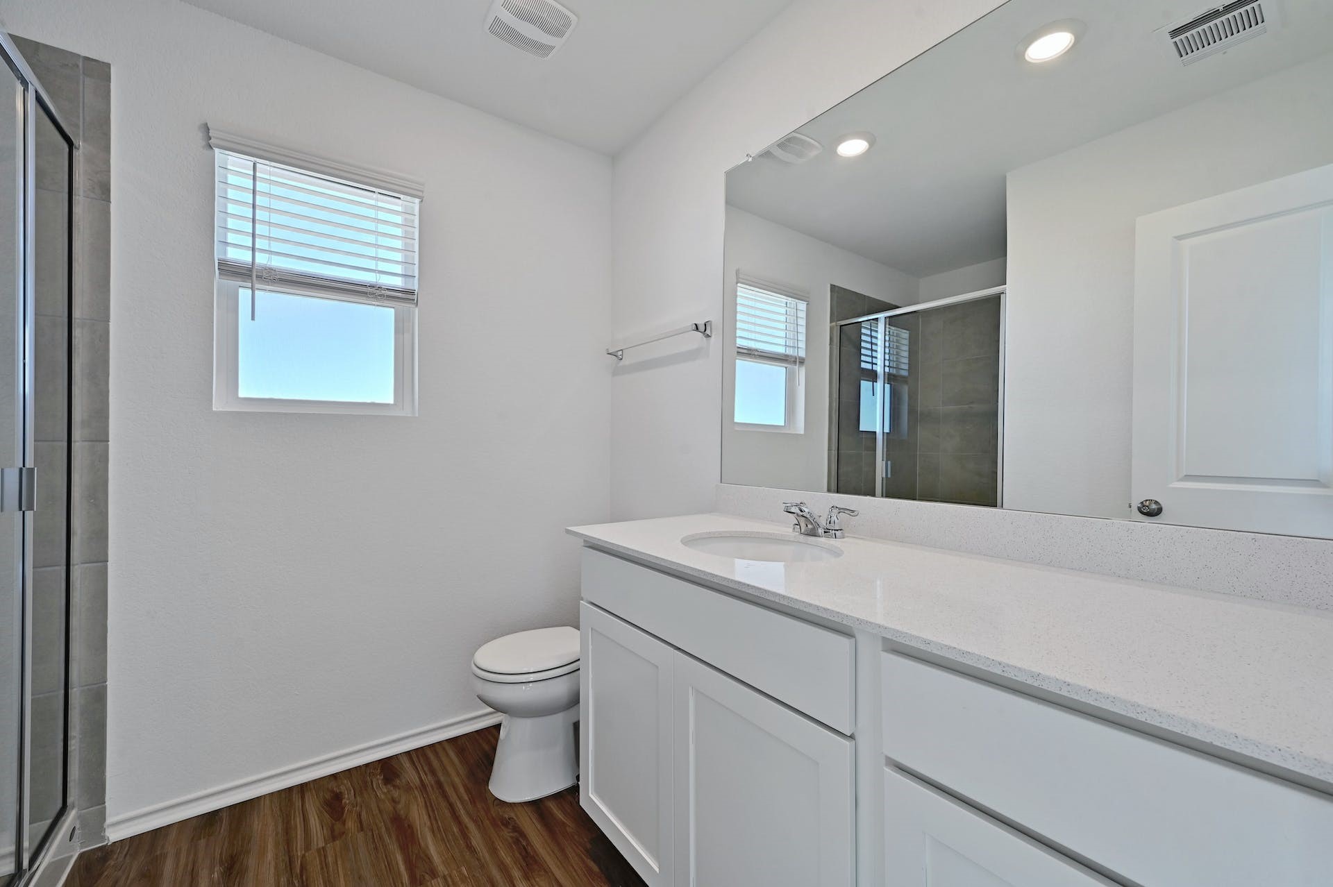 139 Rioja, Unit GARAGE APARTMENT Kyle, TX 78640 - Photo 14 of 16 A well-appointed bathroom features a single vanity with stone counters and wood-look flooring.