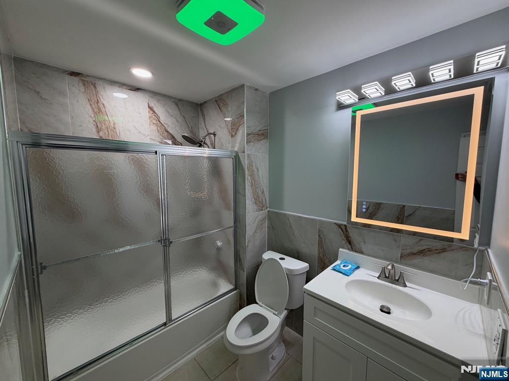 329 Fair Street, Unit 329 Paterson, NJ 07501 - Photo 14 of 14 a bathroom with a sink mirror vanity and toilet