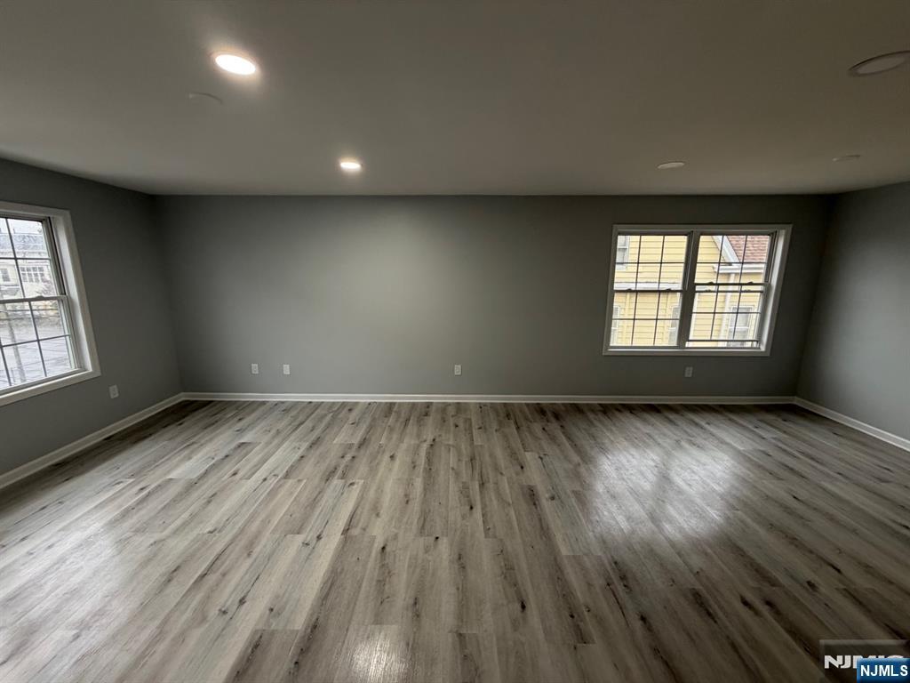329 Fair Street, Unit 329 Paterson, NJ 07501 - Photo 2 of 14 an empty room with wooden floor and windows