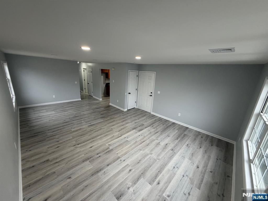 329 Fair Street, Unit 329 Paterson, NJ 07501 - Photo 3 of 14 an empty room with wooden floor and windows