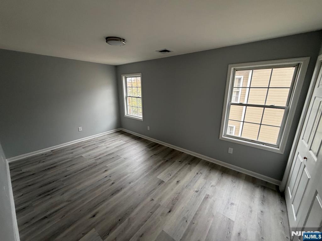 329 Fair Street, Unit 329 Paterson, NJ 07501 - Photo 9 of 14 a view of an empty room with wooden floor and a window