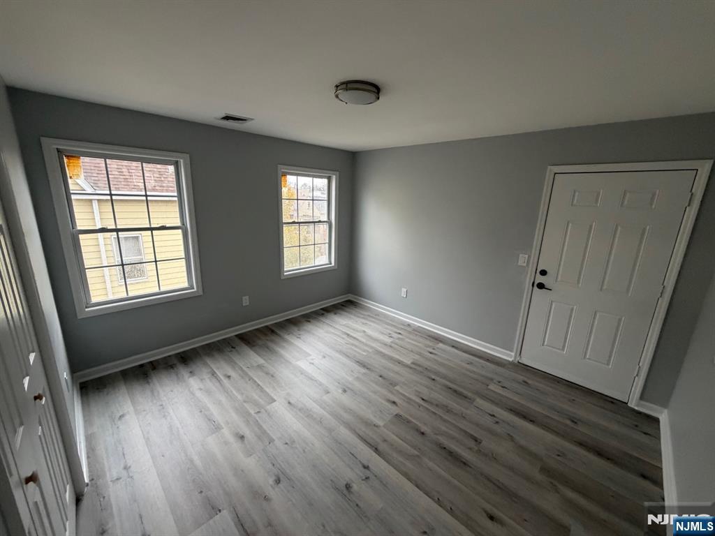 329 Fair Street, Unit 329 Paterson, NJ 07501 - Photo 10 of 14 an empty room with wooden floor and windows