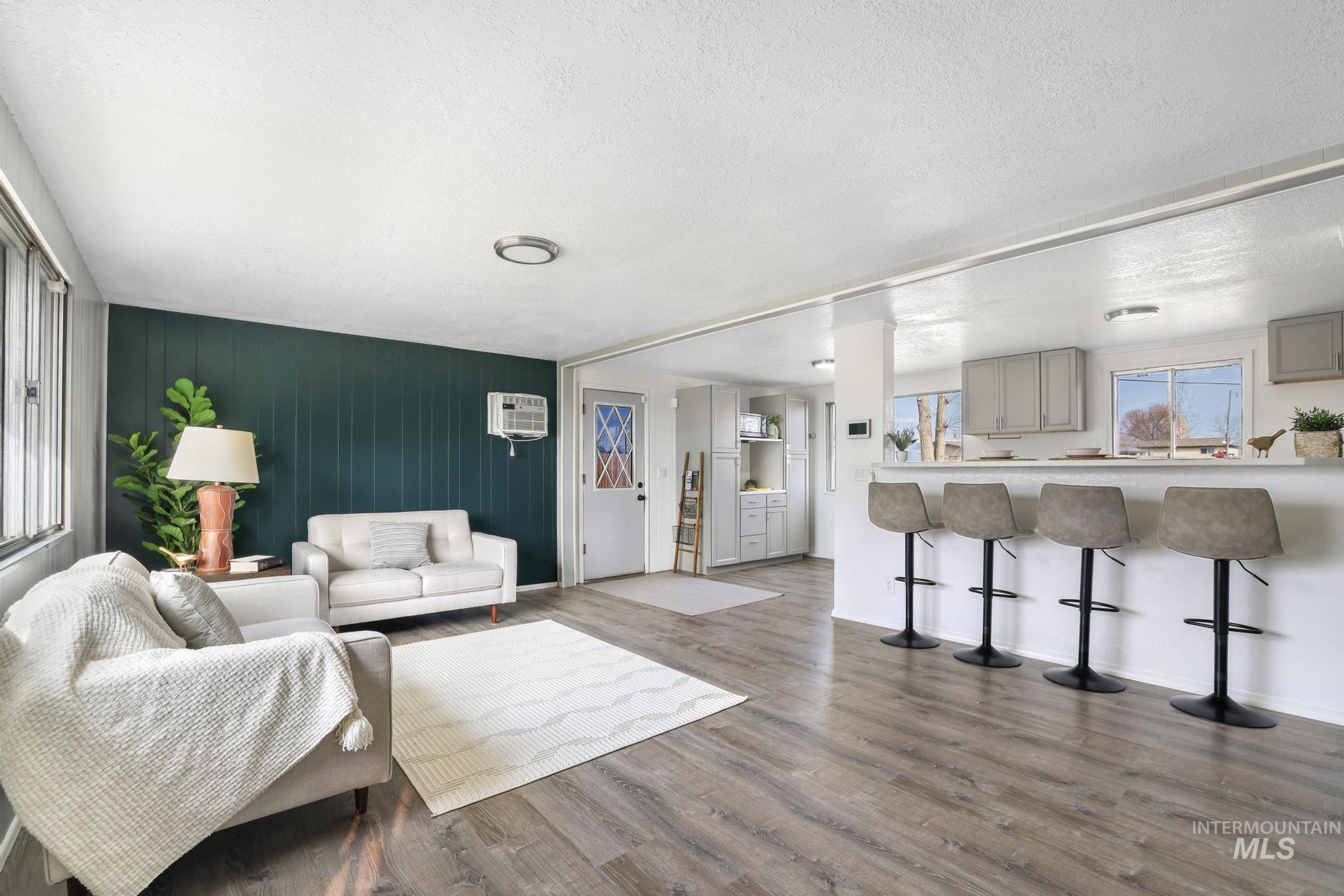 Living area with wood finished floors, wood walls, and a textured ceiling