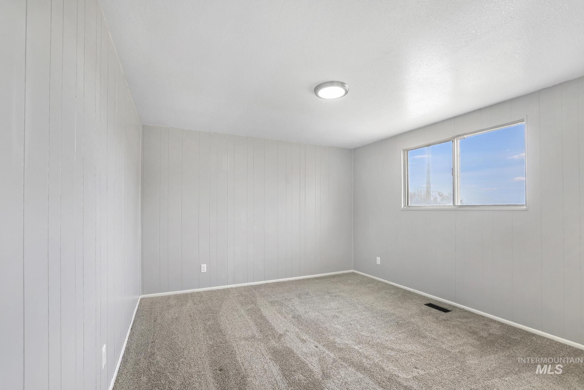 1840 V Street Heyburn, ID 83336 - Photo 12 of 45 Unfurnished room featuring wooden walls and carpet floors