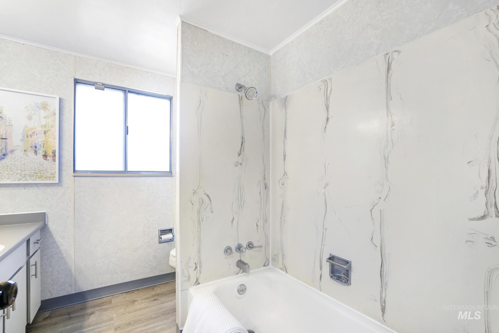 1840 V Street Heyburn, ID 83336 - Photo 16 of 45 Full bath featuring vanity, light wood-style floors, bathing tub / shower combination, and crown molding