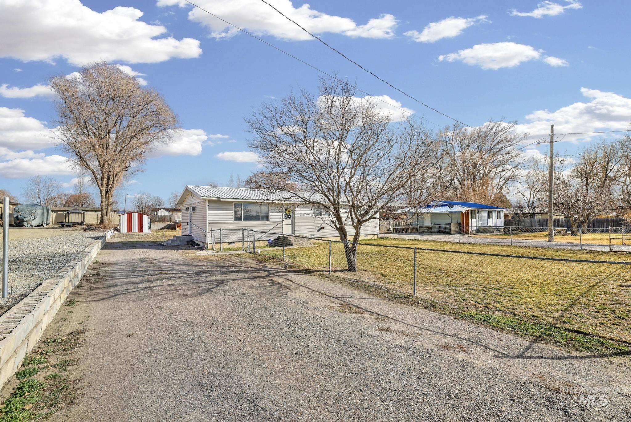 1840 V Street Heyburn, ID 83336 - Photo 26 of 45 View of front of home featuring a residential view, a metal roof, driveway, and a fenced front yard
