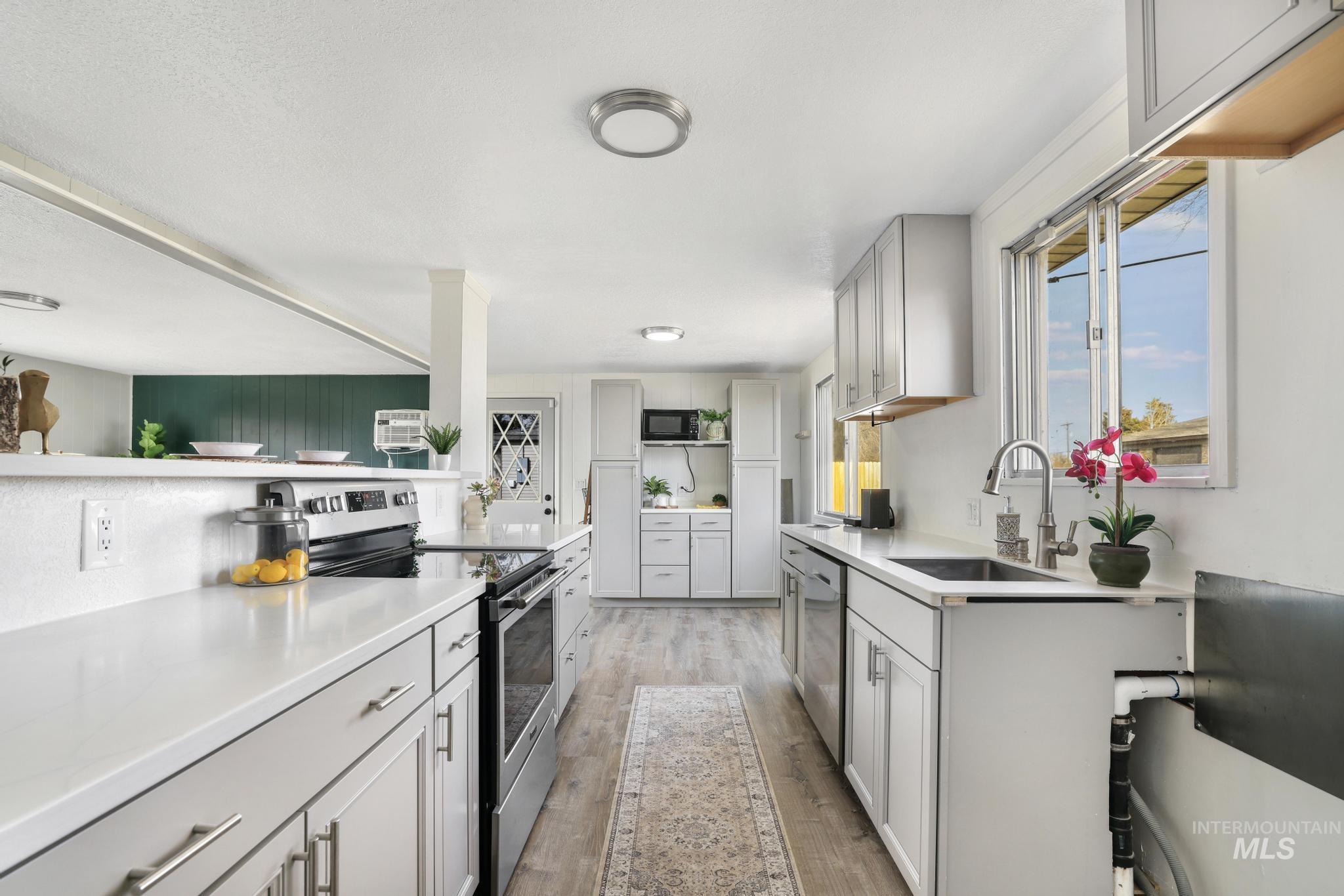 1840 V Street Heyburn, ID 83336 - Photo 5 of 45 Kitchen featuring stainless steel appliances, light wood-style flooring, and gray cabinetry