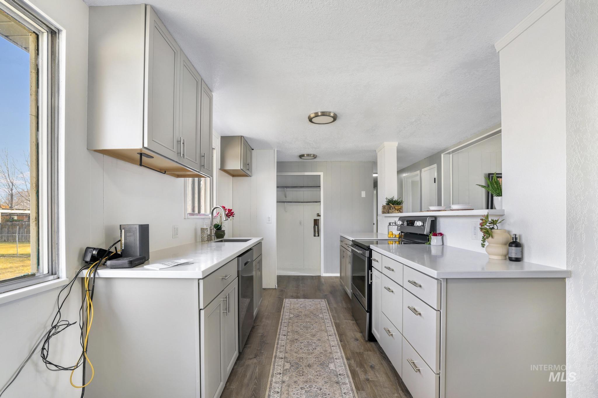 1840 V Street Heyburn, ID 83336 - Photo 8 of 45 Kitchen with stainless steel appliances, gray cabinets, dark wood-style floors, and light stone countertops