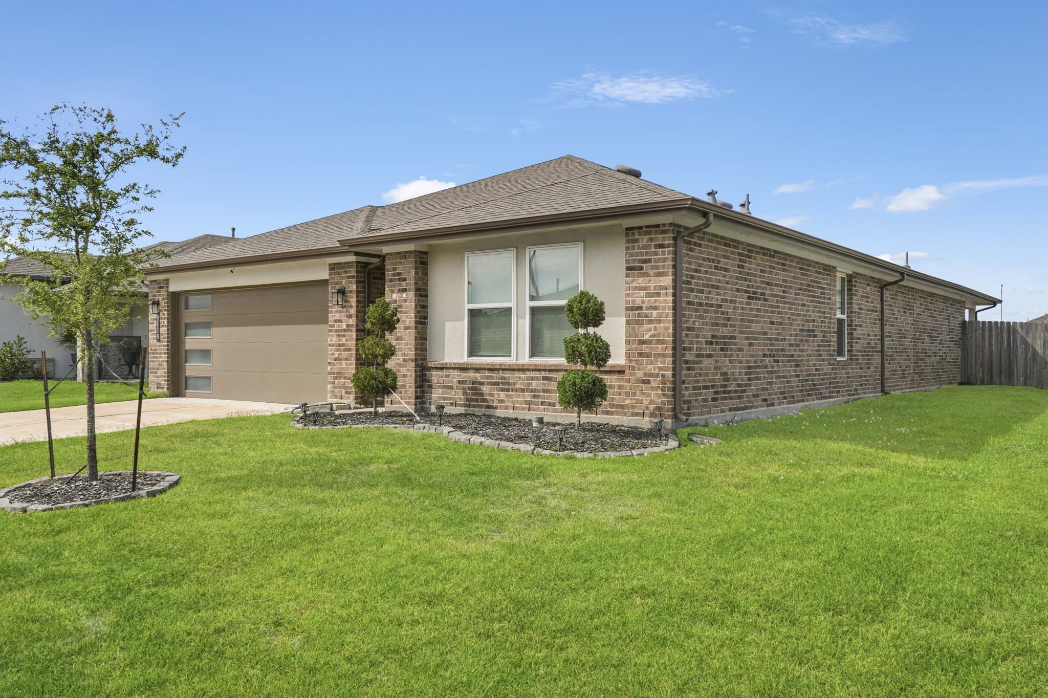8210 Buck Lane Rosharon, TX 77583 - Photo 4 of 30 Well-maintained single-story home with a spacious driveway and attached two-car garage.