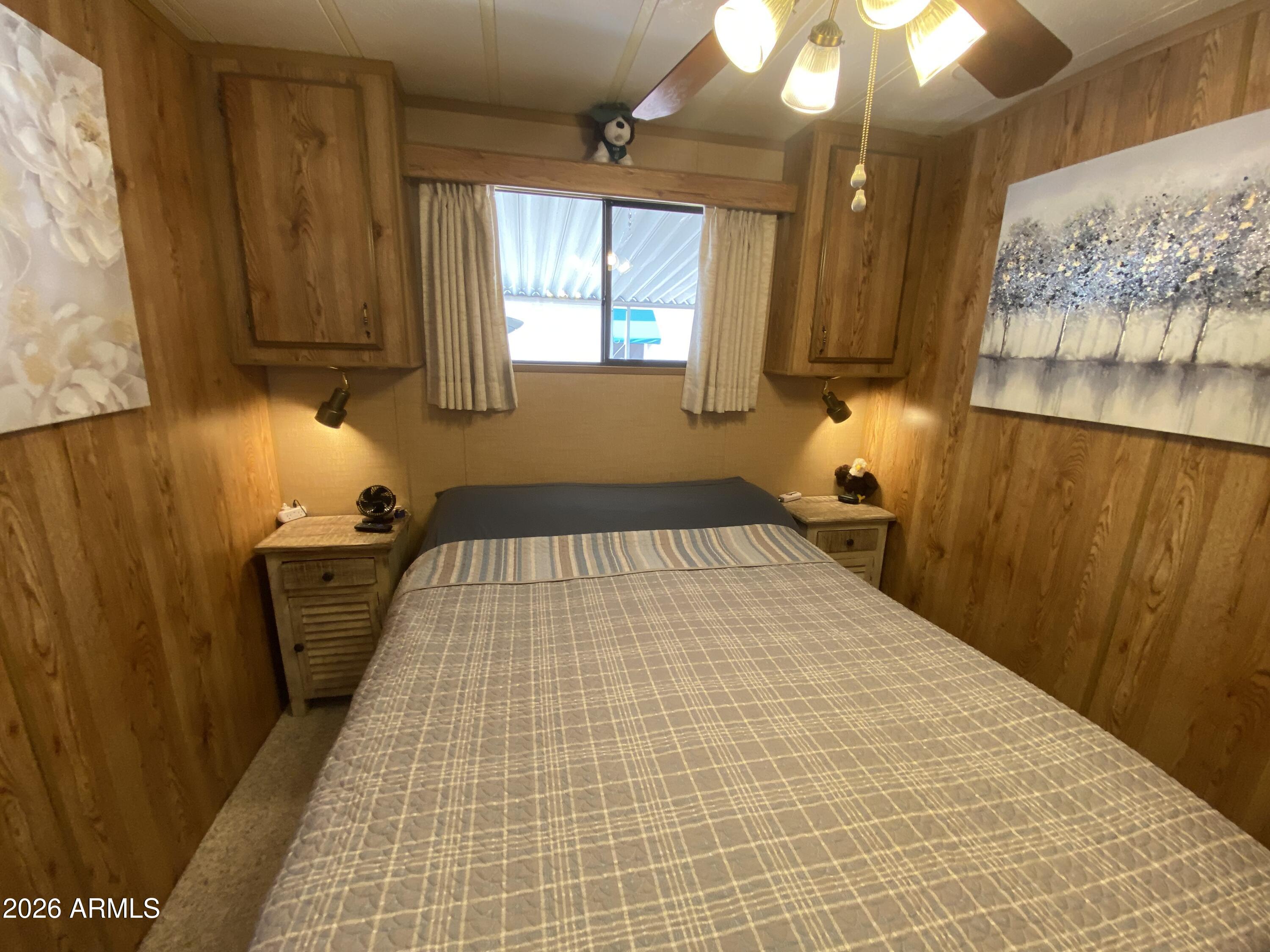 1340 West Inuit Avenue Apache Junction, AZ 85119 - Photo 11 of 30 a bedroom with a bed and a chandelier