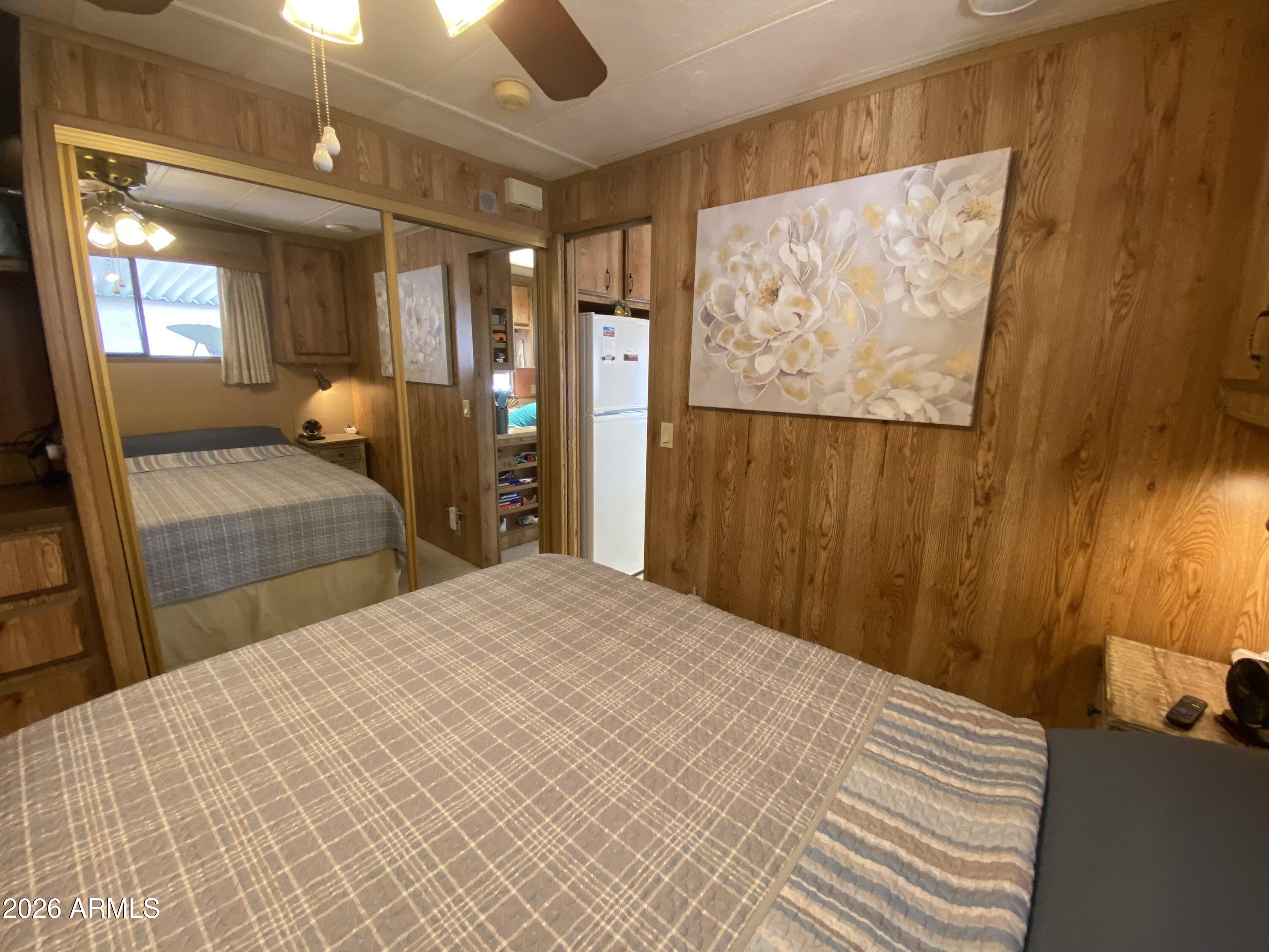 1340 West Inuit Avenue Apache Junction, AZ 85119 - Photo 9 of 30 a bedroom with a large bed and a chandelier