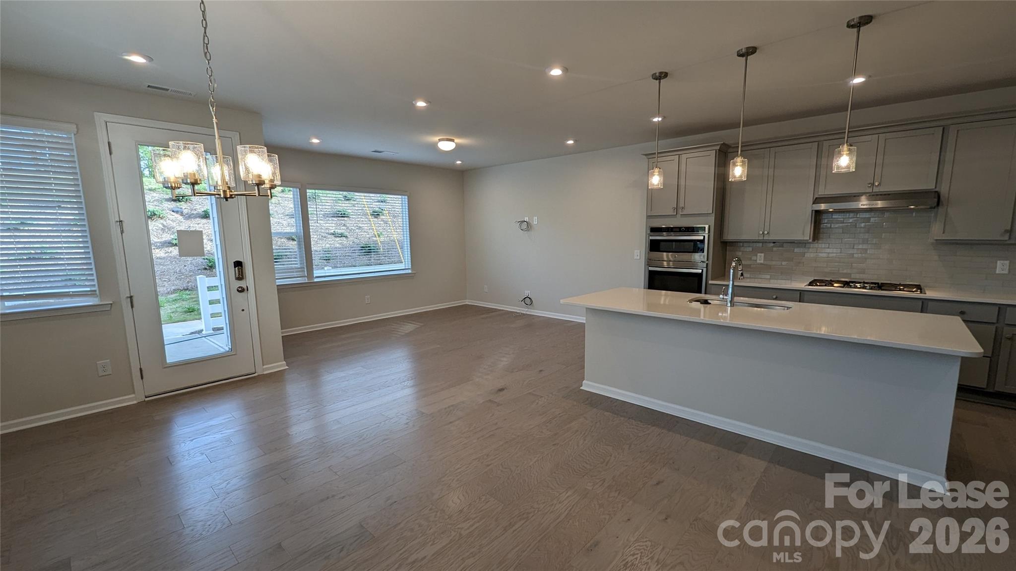 1276 Brawley School Road, Unit F Mooresville, NC 28117 - Photo 14 of 21 a large kitchen with stainless steel appliances a large counter top a stove and a wooden floors