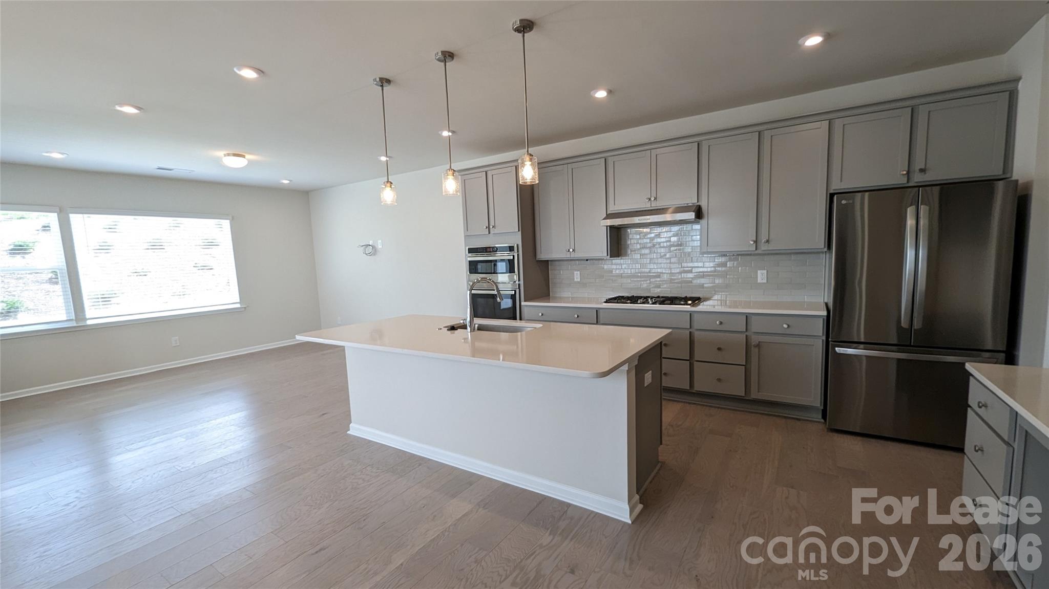 1276 Brawley School Road, Unit F Mooresville, NC 28117 - Photo 5 of 21 a kitchen with kitchen island a sink stainless steel appliances and window