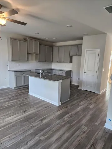 a kitchen with wooden floors and white cabinets