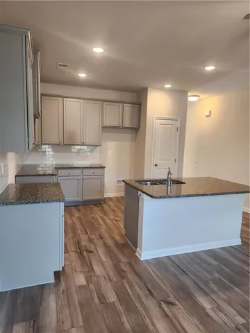 a large kitchen with kitchen island a sink stainless steel appliances and cabinets