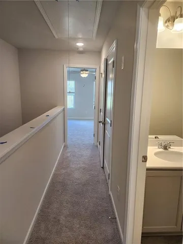 a view of a hallway to a room with wooden floor