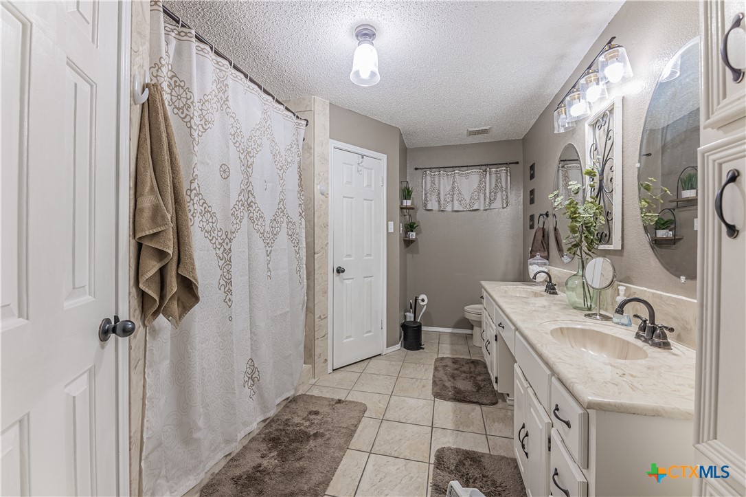 310 North 8th Street Nolanville, TX 76559 - Photo 19 of 31 Bathroom With Sharp White Cabinets, Clean Stylish Fixtures and Mirrors