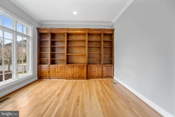 a view of empty room with wooden floor and fireplace