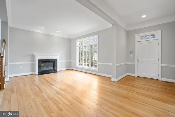 a view of a hallway with wooden floor and windows