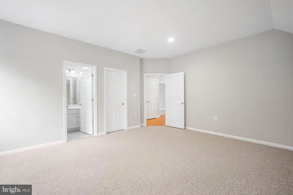 a spacious bathroom with a granite countertop double vanity sink a mirror a bathtub and window