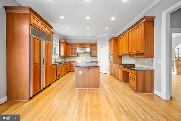 a kitchen with stainless steel appliances granite countertop a stove and a view of living room