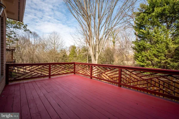 a view of a deck with a large tree and wooden fence