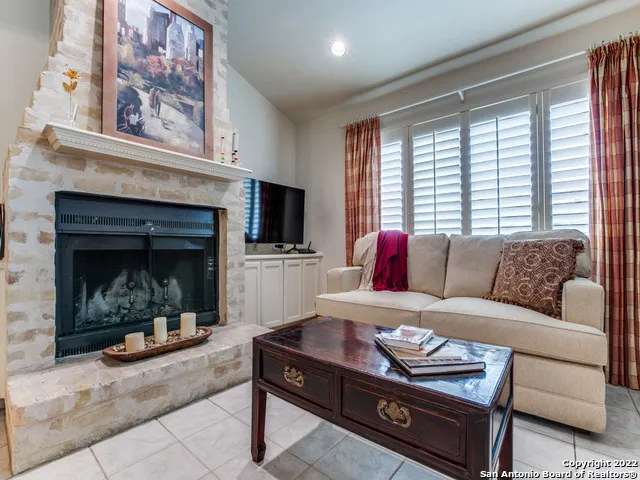 a living room with furniture a fireplace and a large window