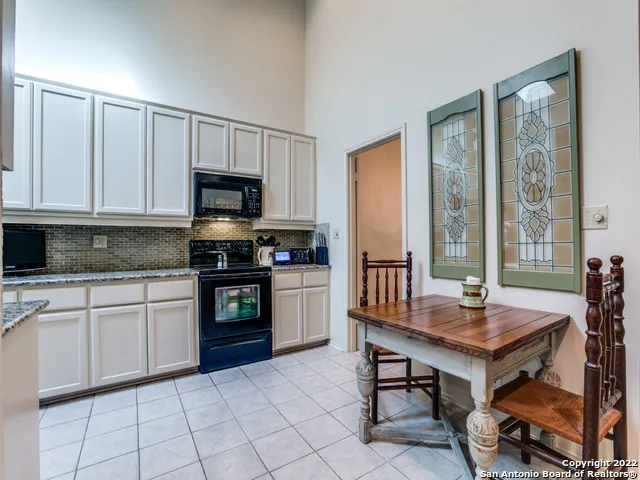 a kitchen with granite countertop a stove a sink and a microwave