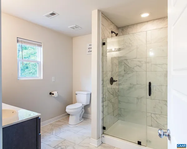 a bathroom with a shower a toilet and a sink