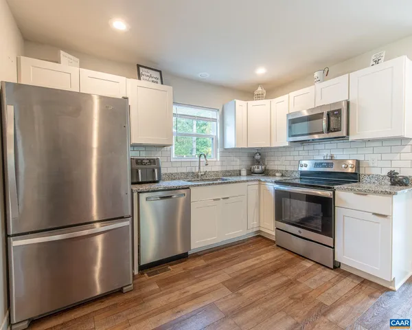 a kitchen with stainless steel appliances a refrigerator sink and microwave