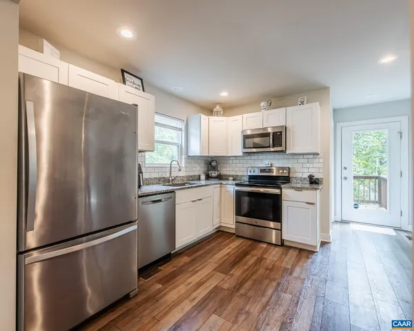 a kitchen with a refrigerator cabinets and wooden floor