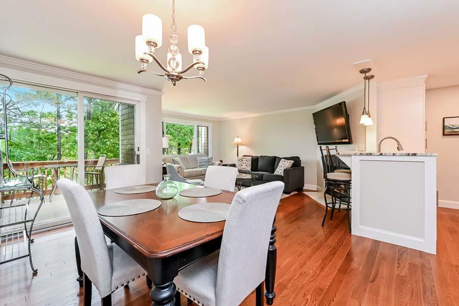 15 Riverview Avenue, Unit B Mashpee, MA 02649 - Photo 11 of 28 a view of a dining room with furniture a chandelier and wooden floor