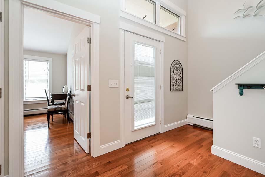 15 Riverview Avenue, Unit B Mashpee, MA 02649 - Photo 2 of 28 a view of a hallway with wooden floor and a livingroom with furniture