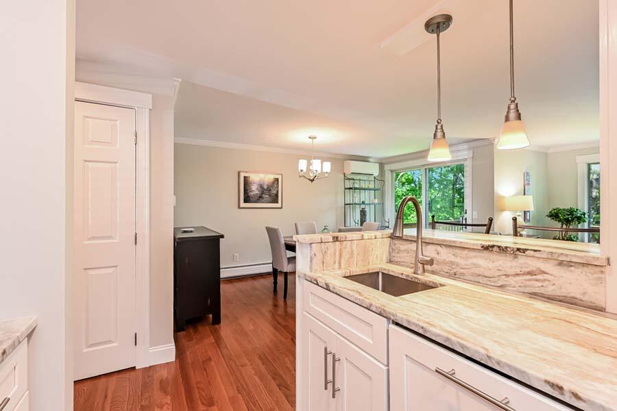 15 Riverview Avenue, Unit B Mashpee, MA 02649 - Photo 6 of 28 a kitchen with stainless steel appliances granite countertop a sink a refrigerator a stove and white cabinets with wooden floor