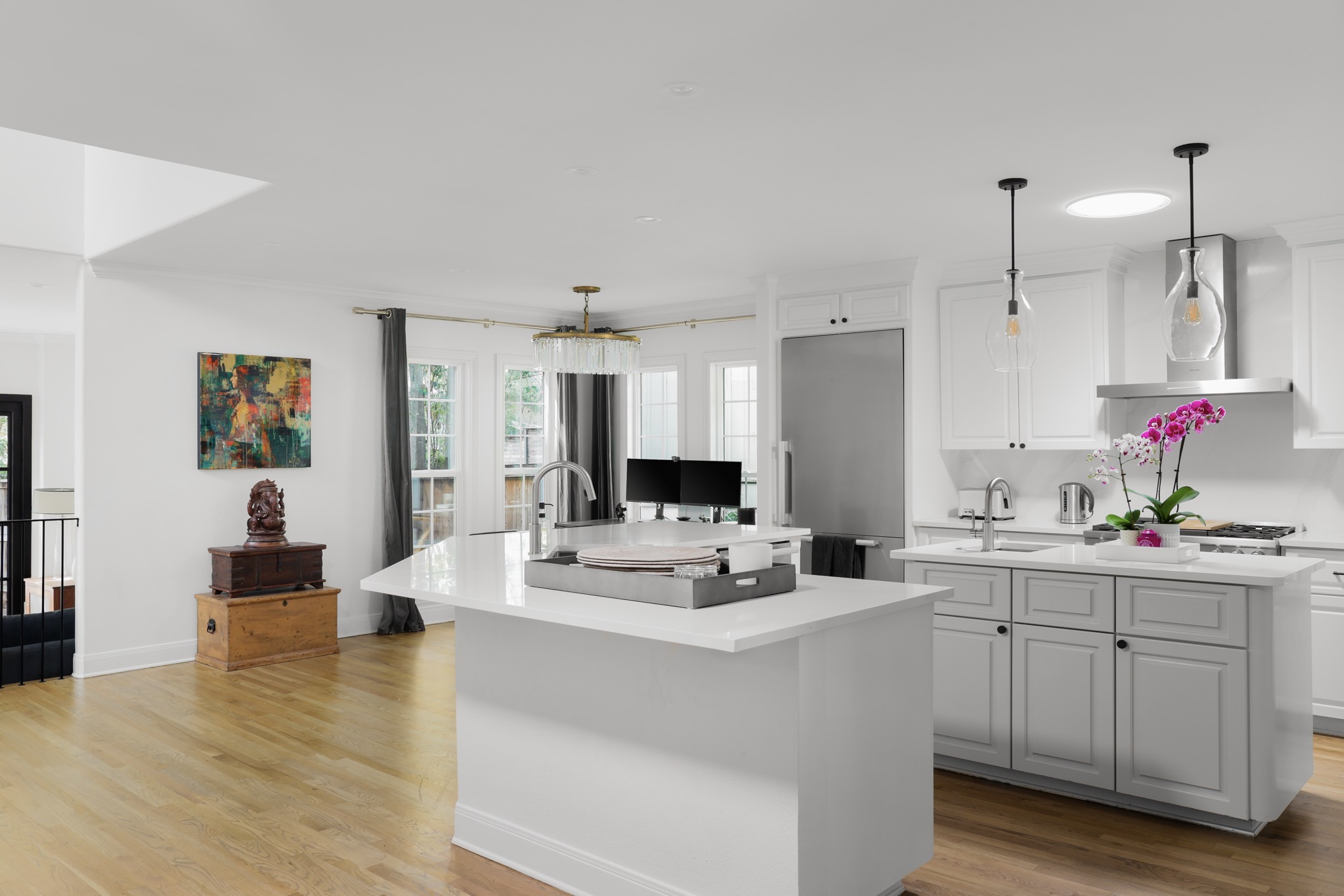 Kitchen featuring light wood-style floors, white cabinets, pendant lighting, light stone counters, and stainless steel built in fridge