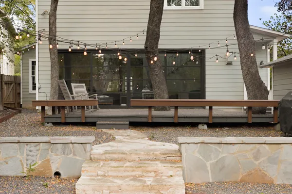 a backyard of a house with barbeque oven table and chairs