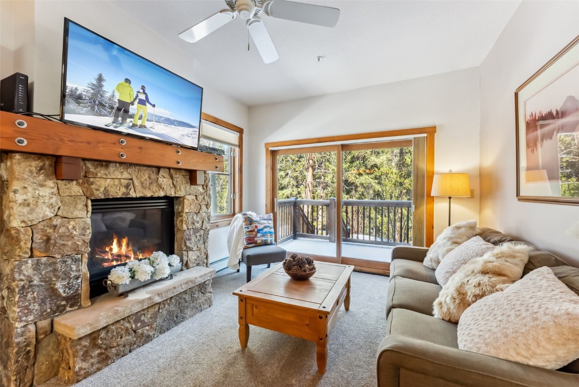 17 Lake Ridge Circle, Unit 1826 Keystone, CO 80435 - Photo 1 of 28 Carpeted living area featuring a healthy amount of sunlight, a ceiling fan, a baseboard heating unit, and a fireplace