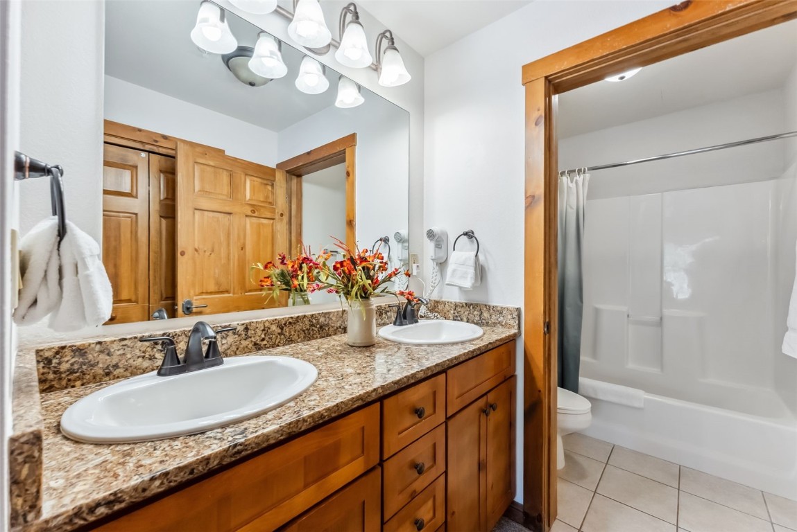 17 Lake Ridge Circle, Unit 1826 Keystone, CO 80435 - Photo 19 of 28 Full bath with a sink, tile patterned floors, double vanity, and toilet