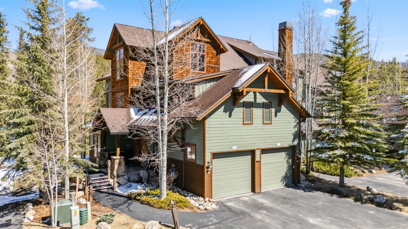 17 Lake Ridge Circle, Unit 1826 Keystone, CO 80435 - Photo 3 of 28 View of property exterior featuring an attached garage, a shingled roof, driveway, and a chimney