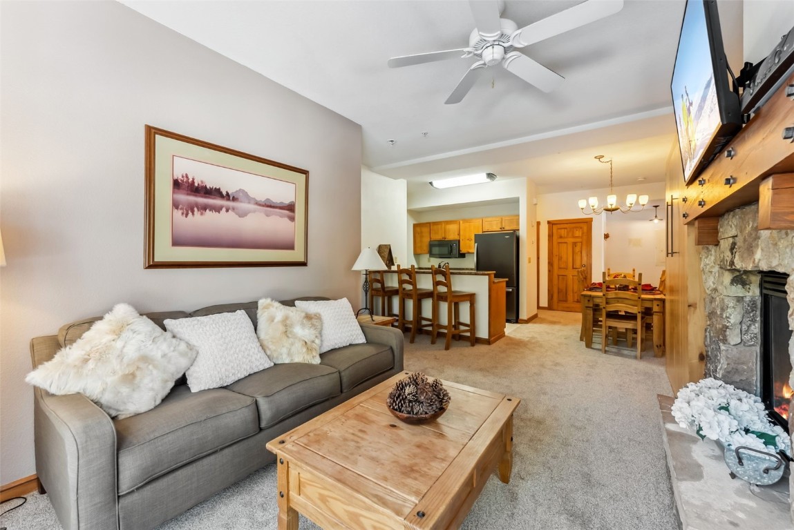 17 Lake Ridge Circle, Unit 1826 Keystone, CO 80435 - Photo 4 of 28 Living room with a fireplace, ceiling fan with notable chandelier, and light colored carpet