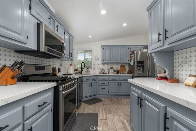 a kitchen with stainless steel appliances granite countertop a sink a stove a microwave and cabinets